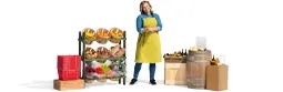 Profile of a shopkeeper next to her basket of goods.